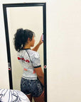 Woman wearing Rising Dragon female grappling shorts and rash guard taking mirror selfie