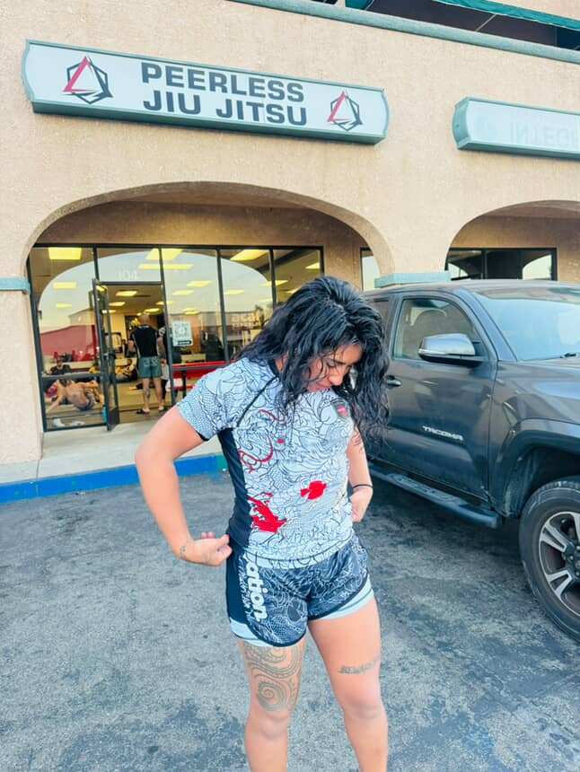 Woman wearing Rising Dragon BJJ Nogi Set in front of Peerless Jiu Jitsu gym