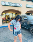Woman wearing Rising Dragon BJJ Nogi Set in front of Peerless Jiu Jitsu gym