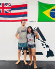 Female athlete wearing Rising Dragon white short sleeve BJJ rash guard practicing martial arts with male partner in gym