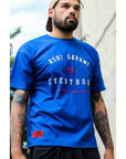 Blue Ashi Garami Varsity oversized BJJ t-shirt with graphic print worn by tattooed man