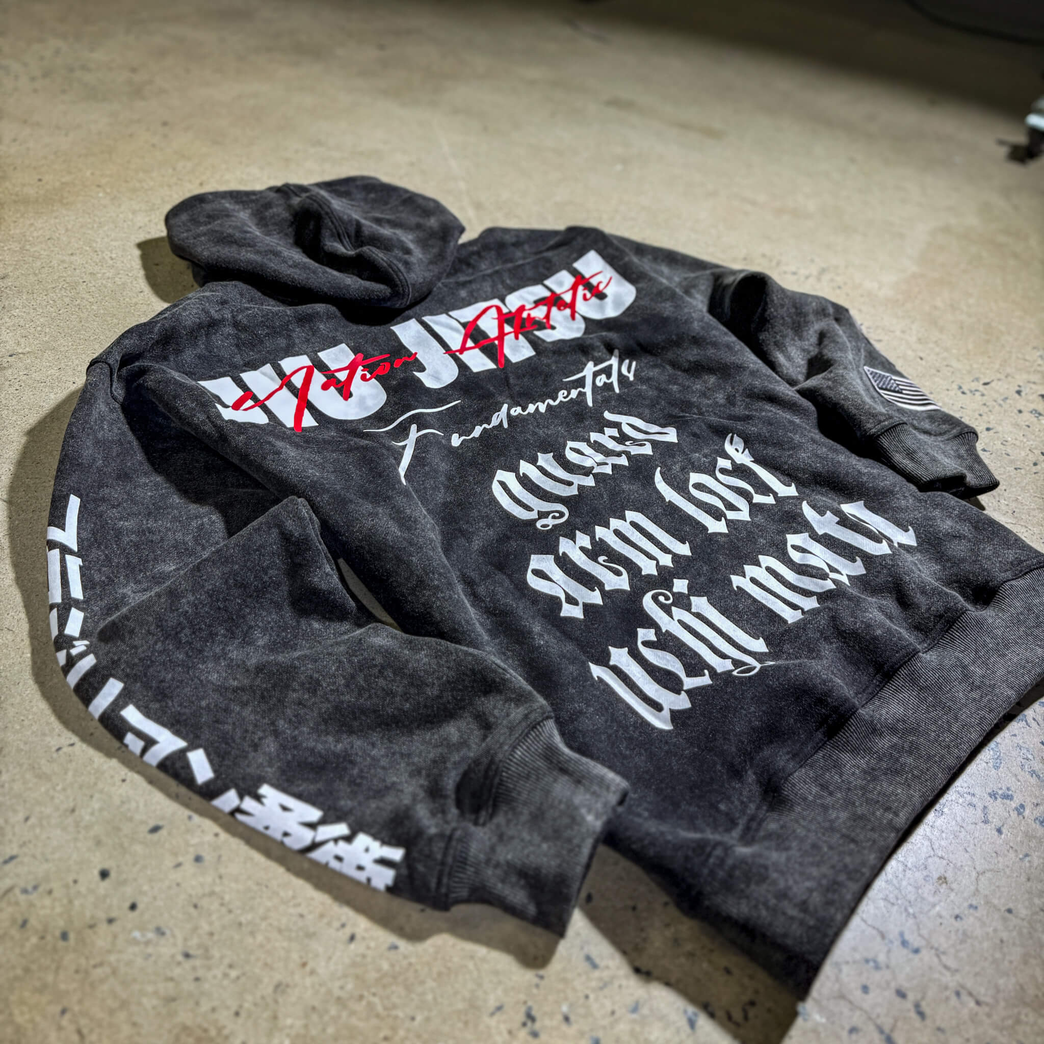 Black acid wash BJJ hoodie with bold Jiu-Jitsu graphics, showcasing grit and durability for combat enthusiasts.