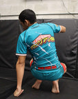 Person wearing a blue athletic outfit with visible branding on a black mat.
