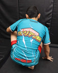 Person wearing a blue martial arts uniform with visible text and logos on a black background
