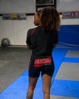 Person wearing a black athletic outfit with 'NATION' branding in a gym setting
