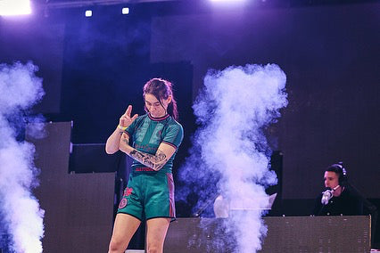 The Hooligans BJJ No Gi Female Set worn during a performance with smoke effects in the background.