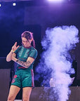 The Hooligans BJJ No Gi Female Set worn during a performance with smoke effects in the background.