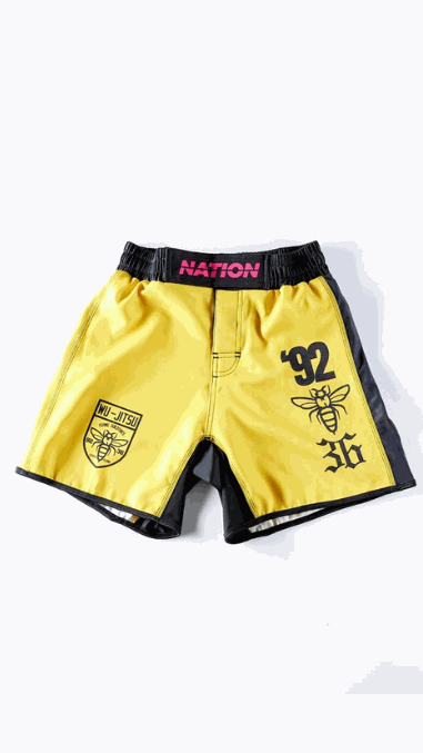 Yellow BJJ grappling shorts with black side panels, featuring '92' and logo graphics, designed for high-performance no-gi Jiu Jitsu.