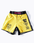 Yellow BJJ grappling shorts with black side panels, featuring '92' and logo graphics, designed for high-performance no-gi Jiu Jitsu.
