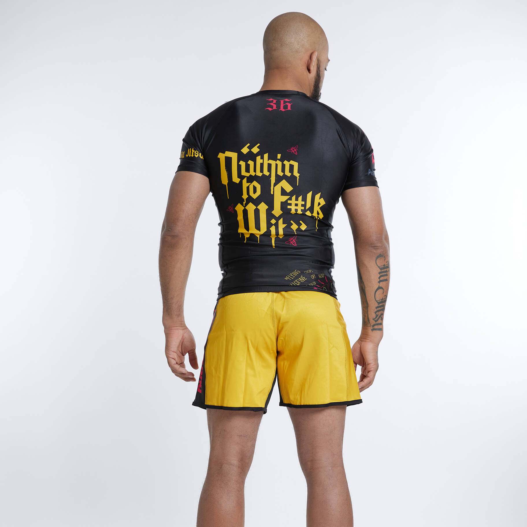 Multicolor Wu Jitsu BJJ Rash Guard Set, male model in yellow shorts and black rash guard, hip hop inspired design.