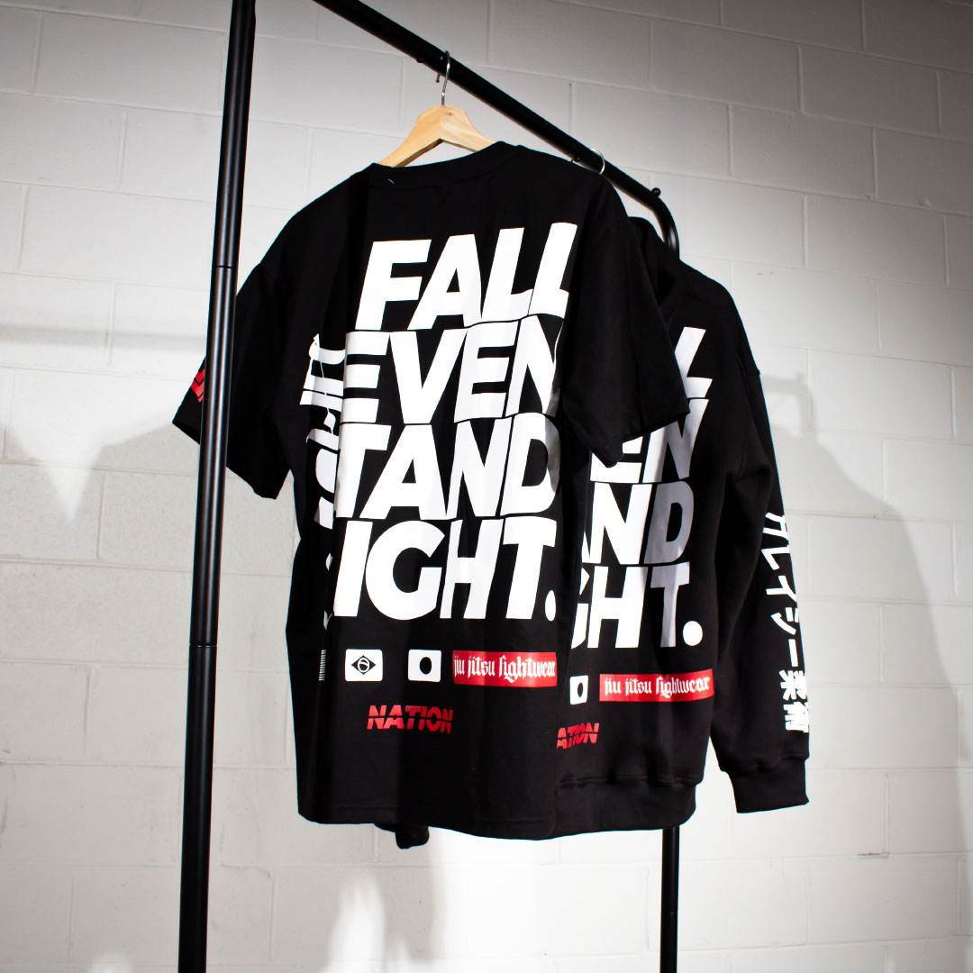 Fall Seven, Stand Eight black nation athletic bjj tee on rolling rack