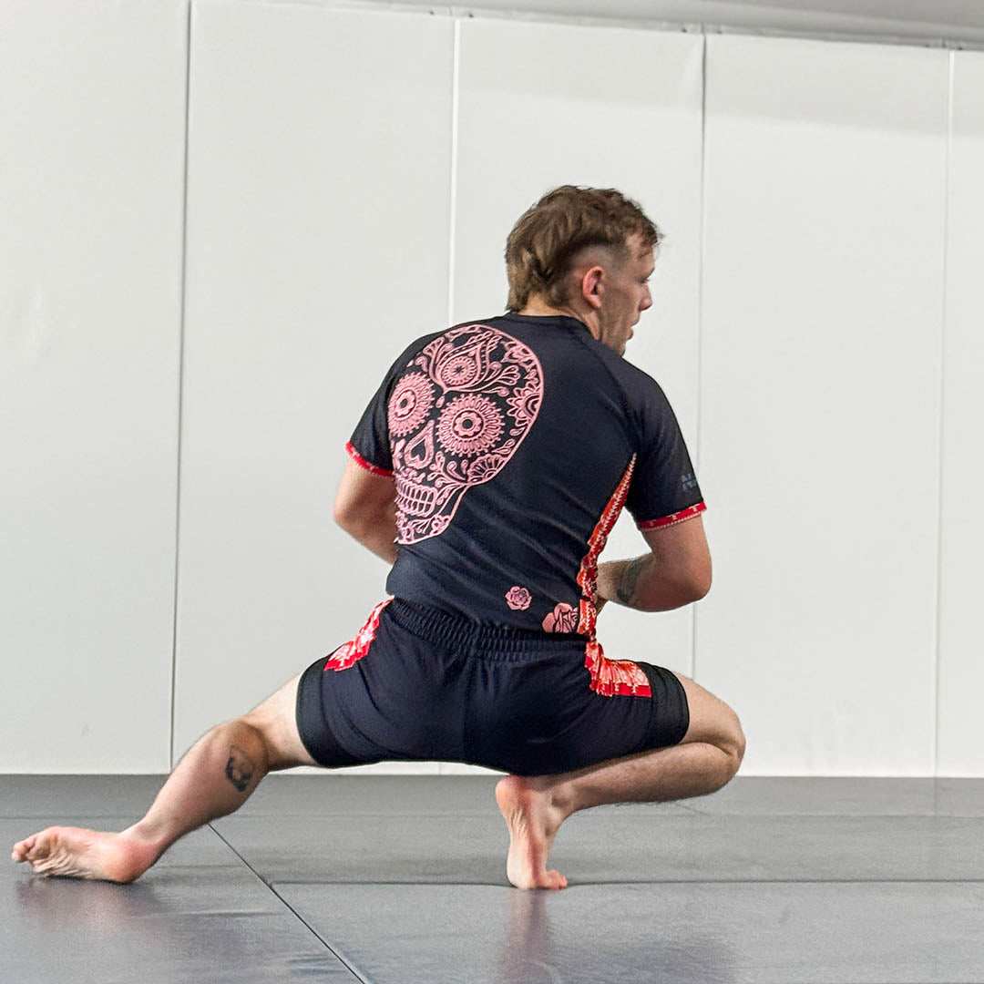 Cucuy Hunter BJJ Rash Guard Set with skull design, featuring a man in crouched position on a mat.