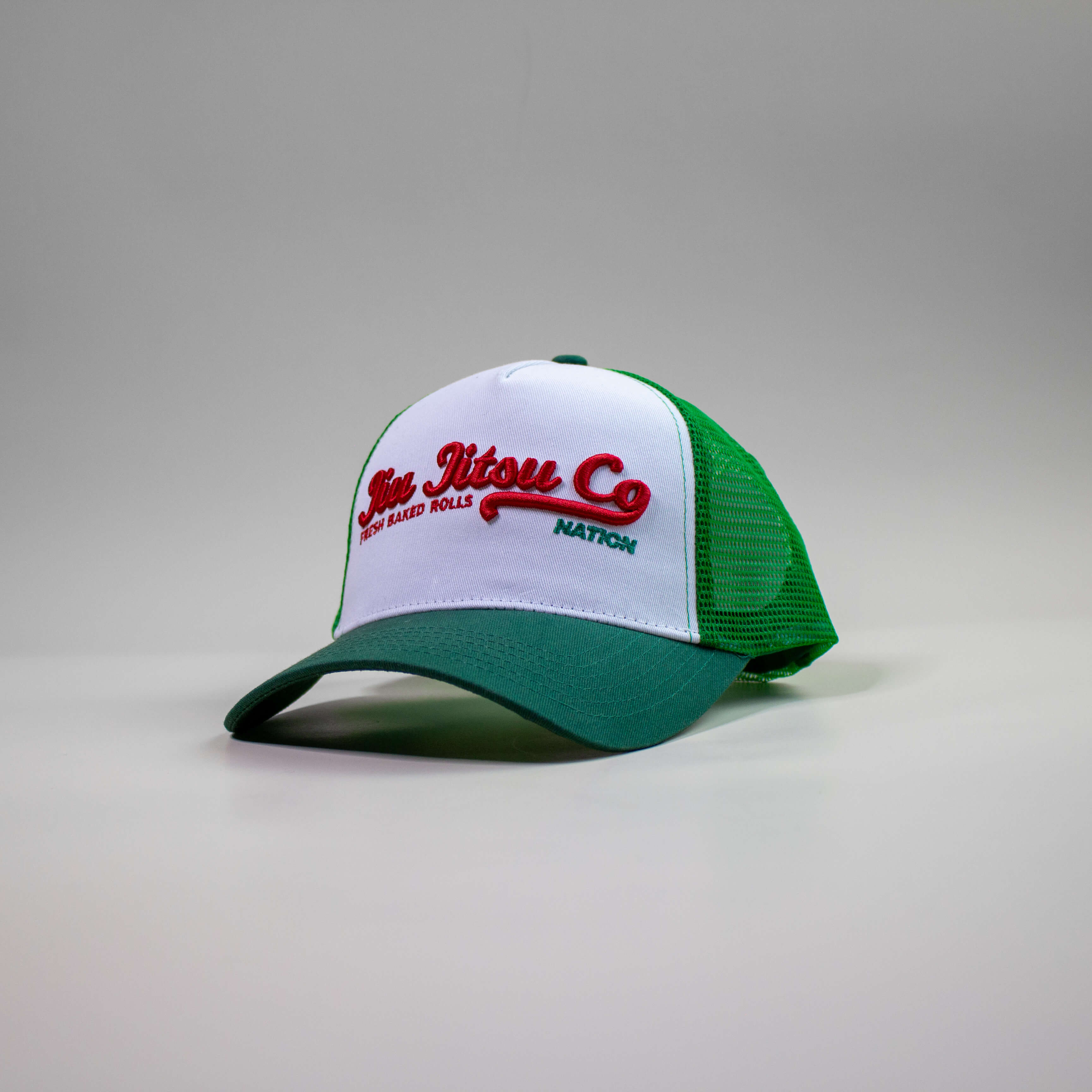 Green and red Jiu Jitsu Supply Co trucker hat with mesh back and 3D embroidery.