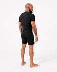 Man wearing a black athletic outfit on a white background