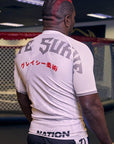 White BJJ Rash Guard with graphic design and text, worn by a person in a gym setting, showcasing durable and breathable compression fit for No-Gi Jiu Jitsu training.