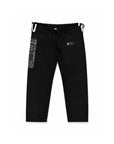 Black Brazilian jiu jitsu kimono pants with a drawstring waist, featuring a vertical black-and-white patterned panel on the left leg and a small black brand patch on the right thigh, shown against a plain white background.