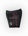 Black athletic shorts with green and red accents on a white background