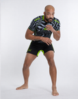 Man wearing a black and gray sports outfit with green accents on a white background