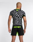 Person wearing a black and gray patterned athletic shirt and shorts with 'NATION' branding on a white background