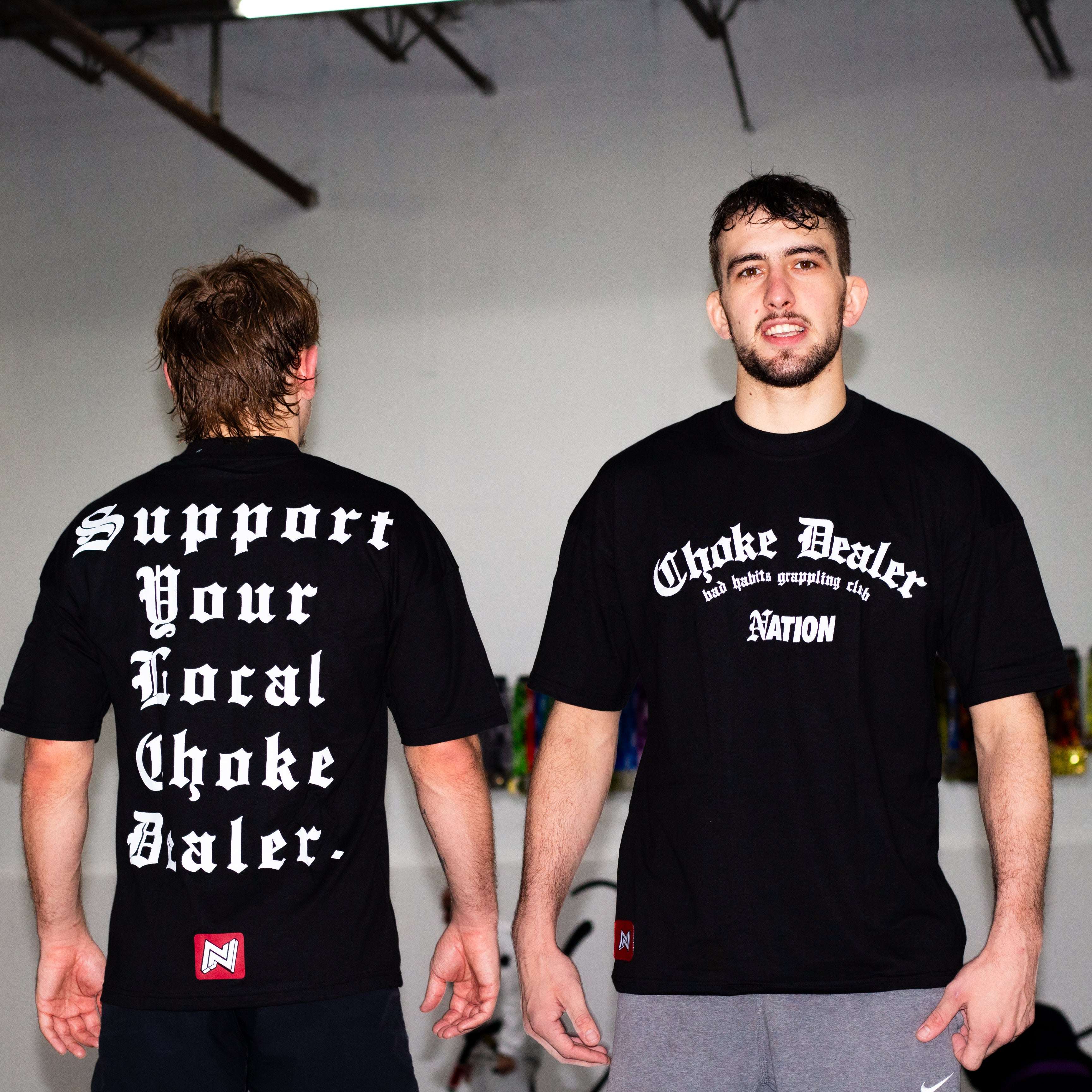 Two man wearing a black t shirt with writings