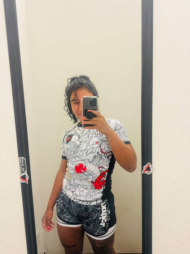 Woman wearing Rising Dragon BJJ Nogi Set in white with dragon design taking a mirror selfie