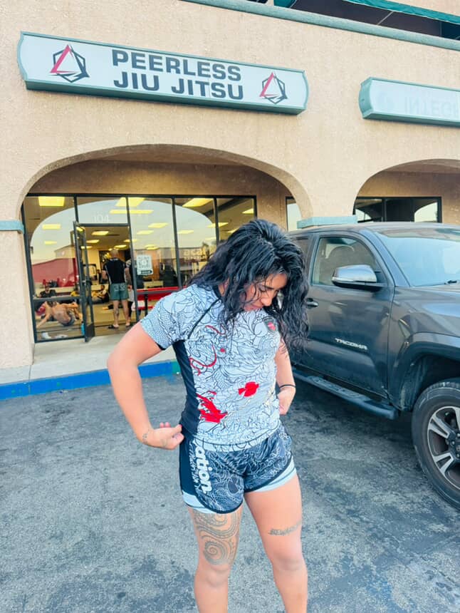 Woman wearing Rising Dragon BJJ Nogi Set in front of Peerless Jiu Jitsu gym