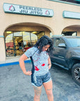 Woman wearing Rising Dragon BJJ Nogi Set in front of Peerless Jiu Jitsu gym