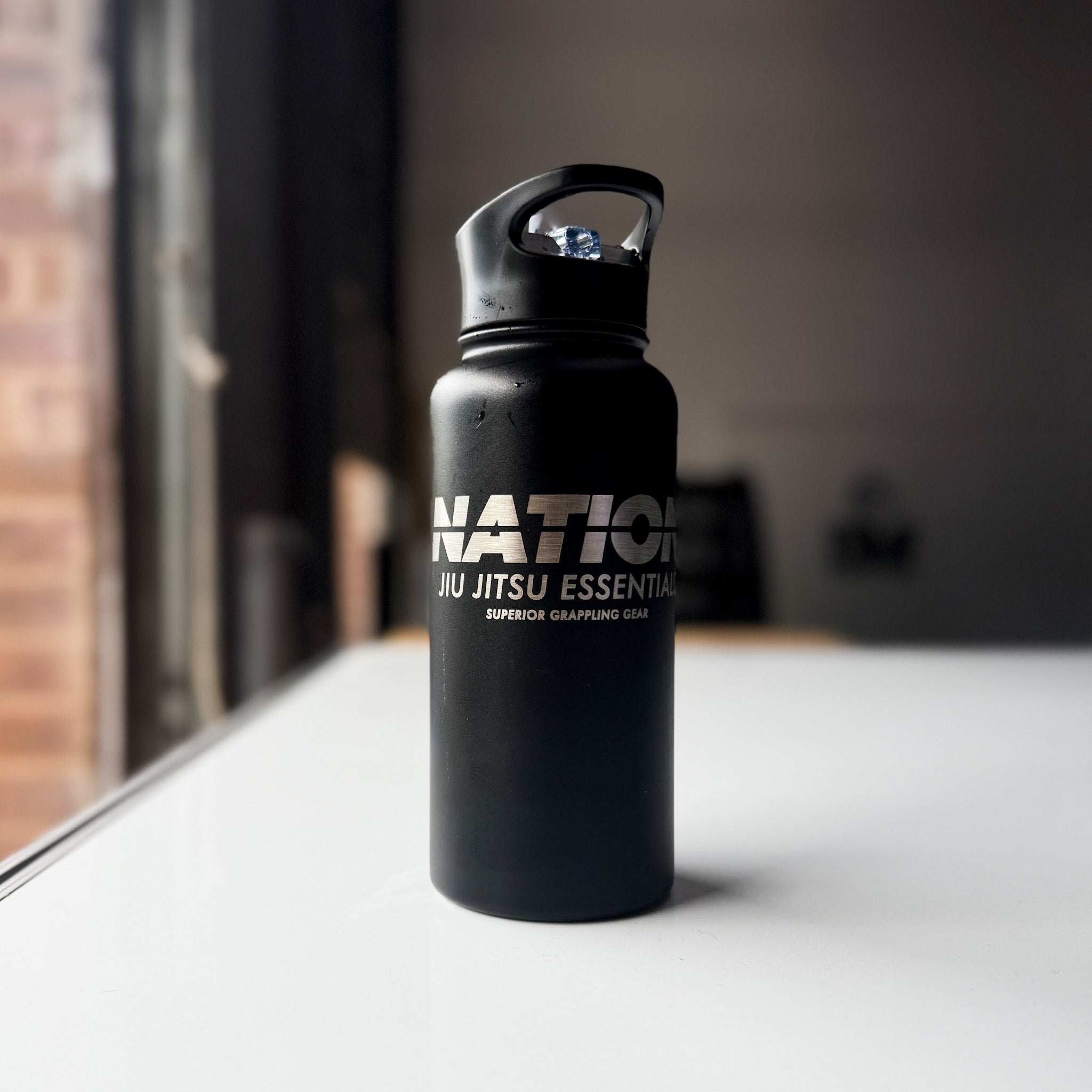 34oz stainless steel BJJ water bottle with laser-etched logo for jiu jitsu athletes.