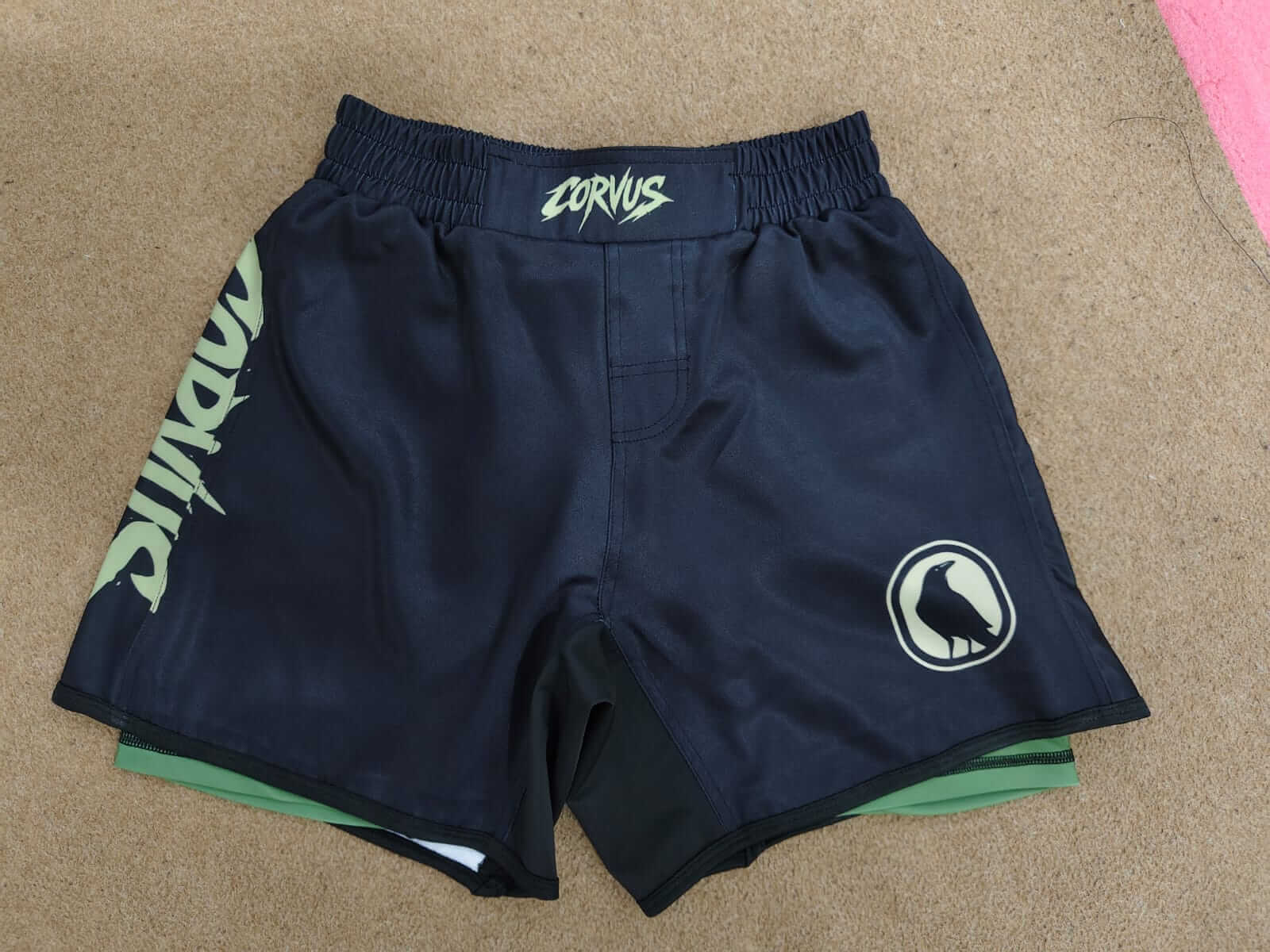 Navy blue shorts with logos on a beige surface