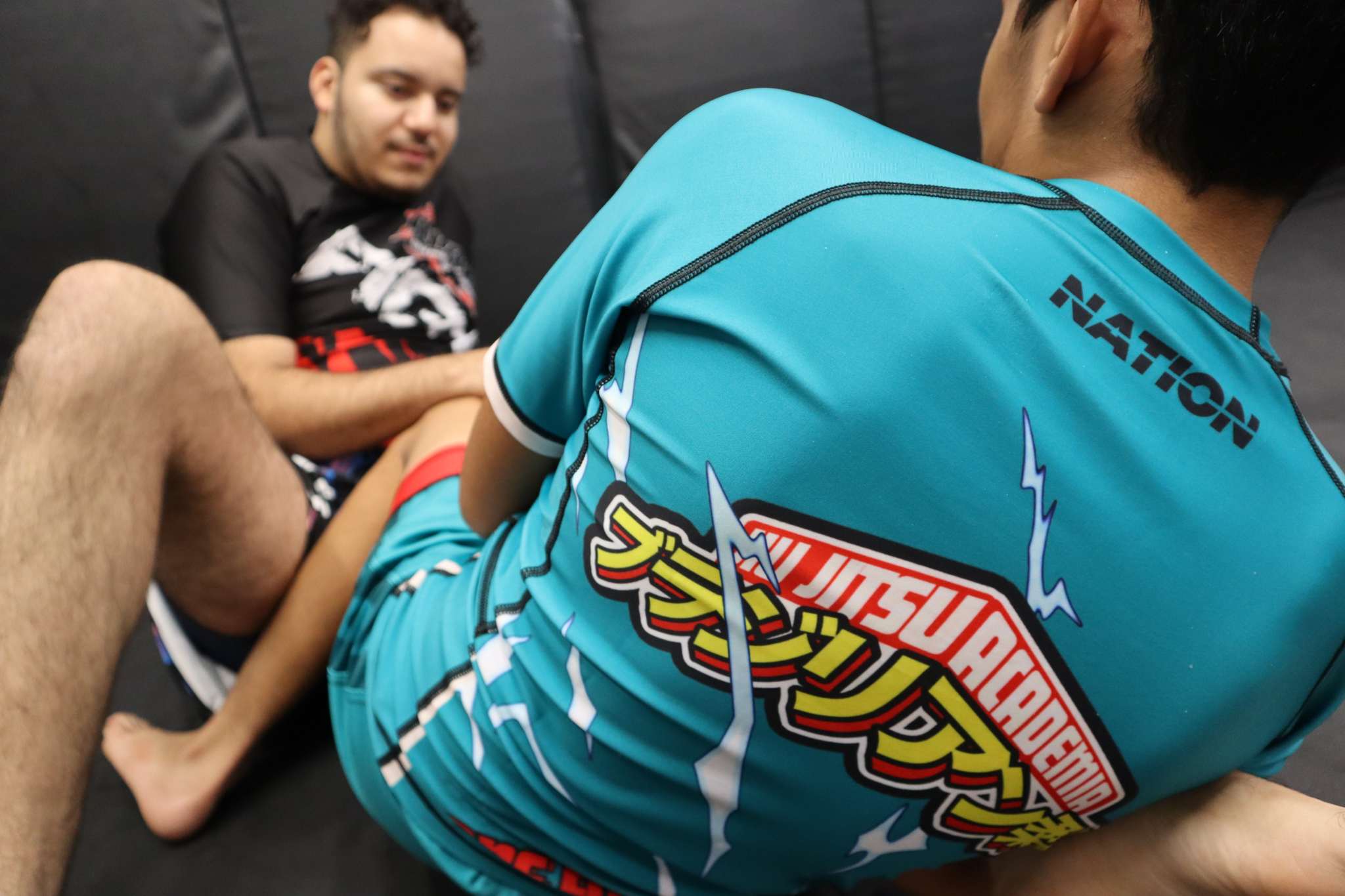 Person wearing a blue martial arts uniform with visible branding