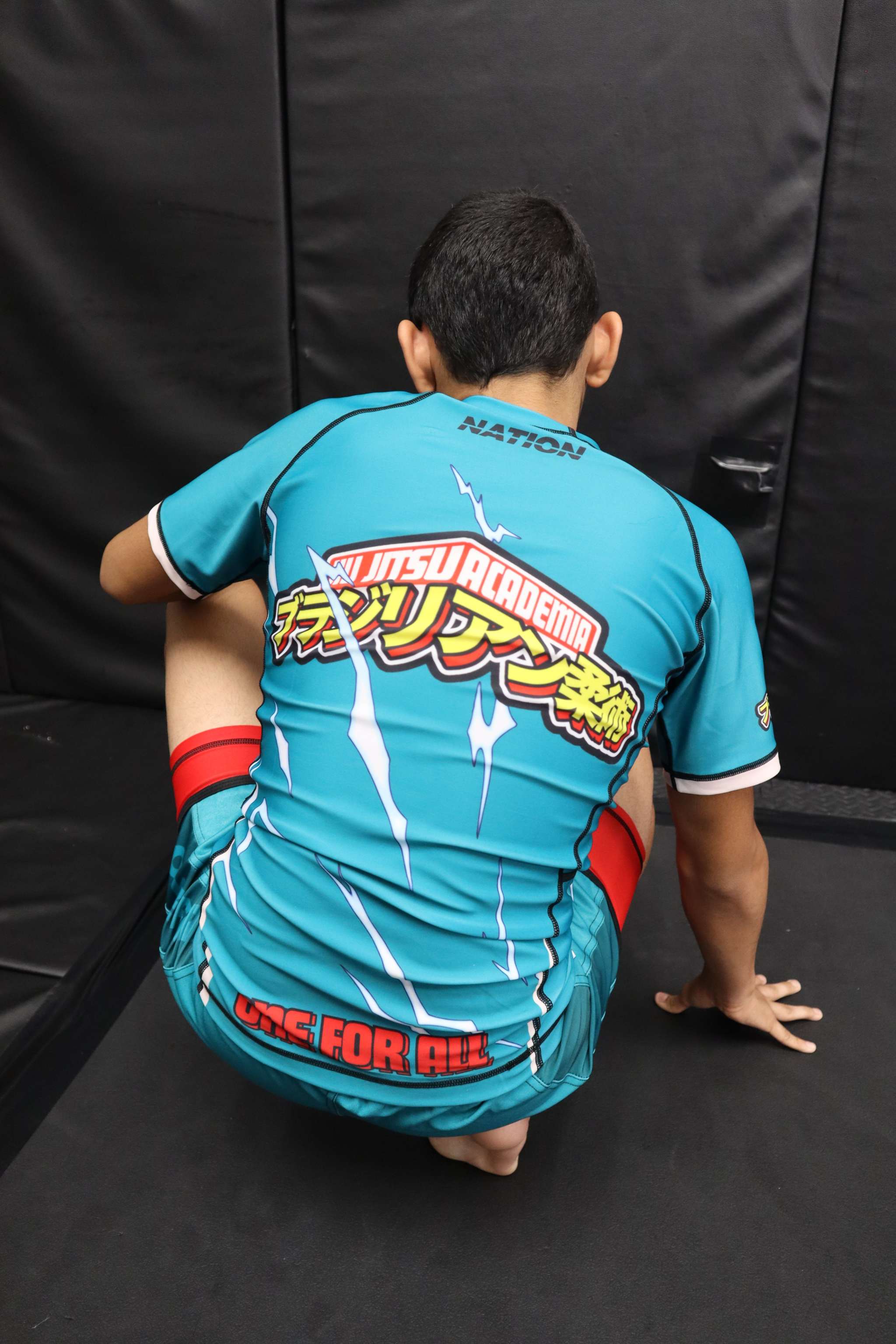 Person wearing a blue martial arts uniform with visible text and logos on a black background