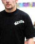 Person wearing a black bjj t-shirt with a white logo in an indoor setting