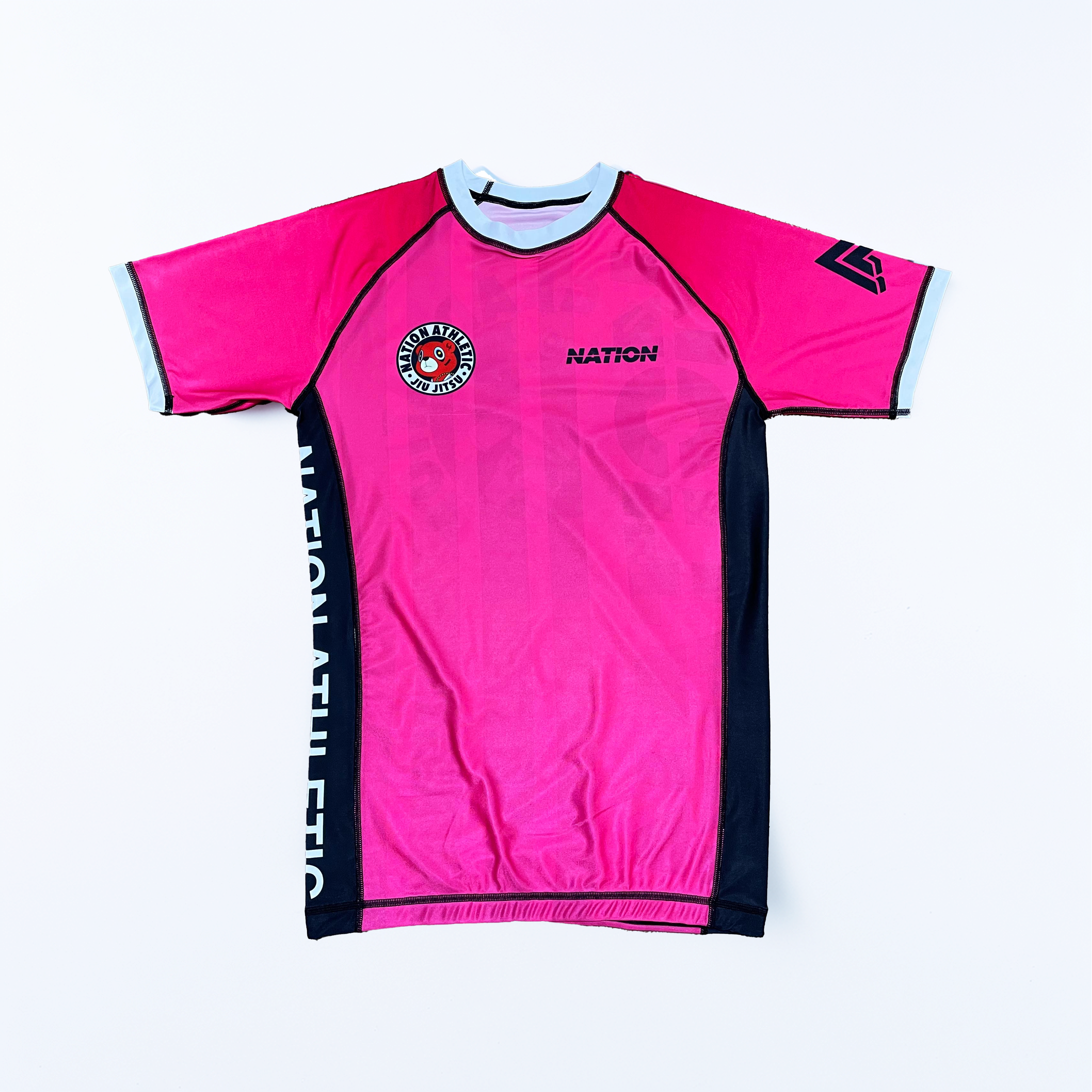 Pink Kanye BJJ rash guard with black side panels, moisture-wicking fabric, and Nation Athletic logos for no-gi Brazilian jiu-jitsu training.