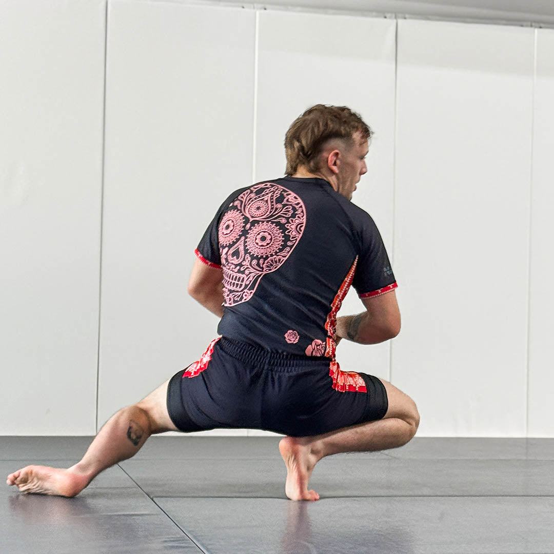 Cucuy Hunter BJJ Rash Guard Set with skull design, featuring a man in crouched position on a mat.