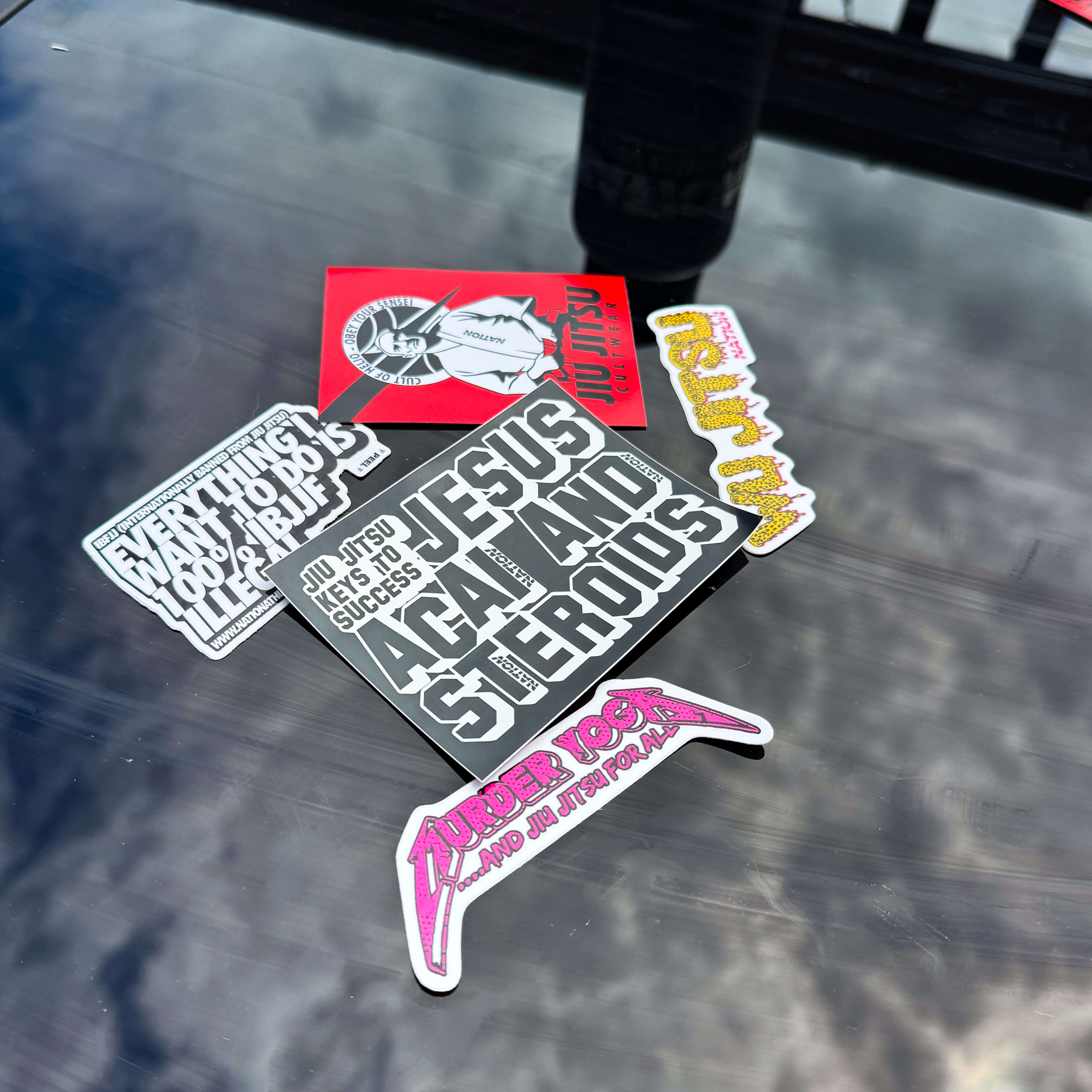 Set of premium BJJ stickers with bold text and graphics for Jiu Jitsu enthusiasts on glossy surface
