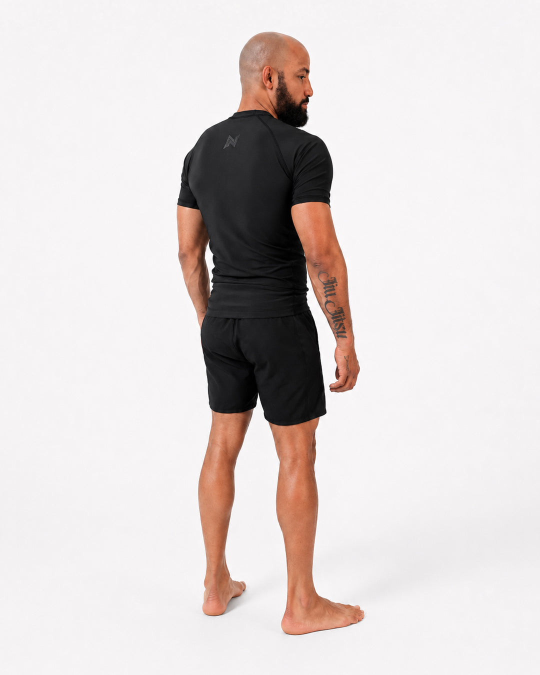 Man wearing a black athletic outfit on a white background