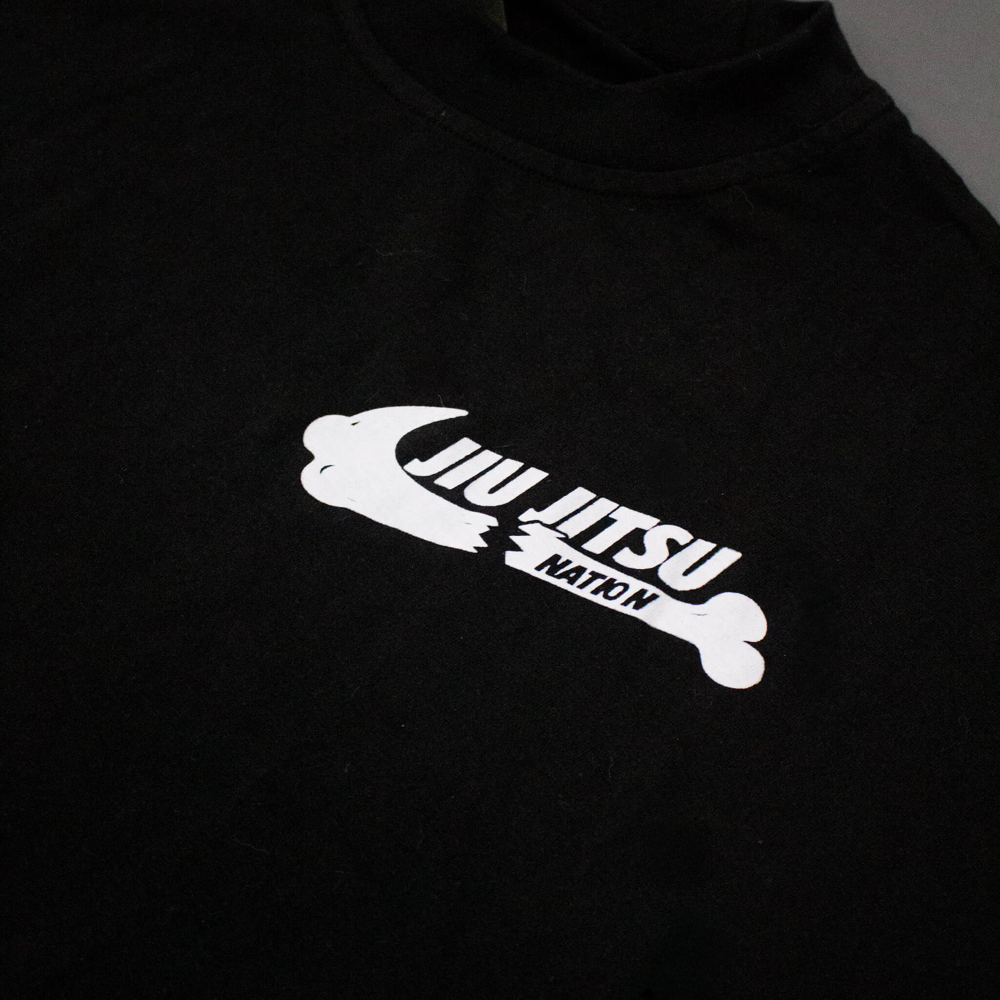 Black t-shirt with white 'JJN' logo on a dark background