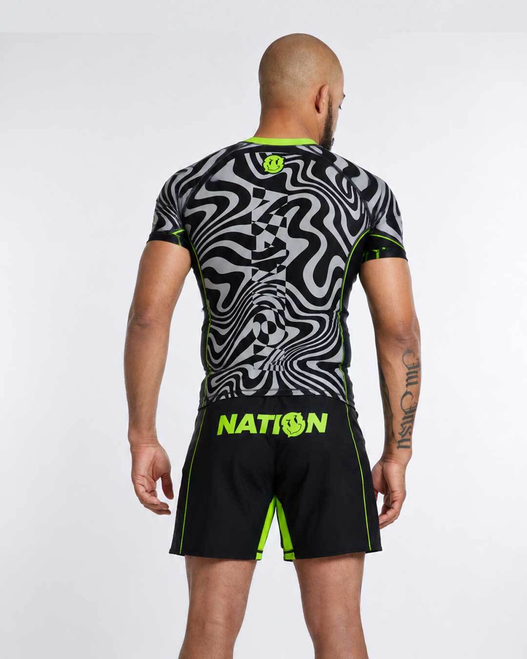 Person wearing a black and gray patterned athletic shirt and shorts with 'NATION' branding on a white background