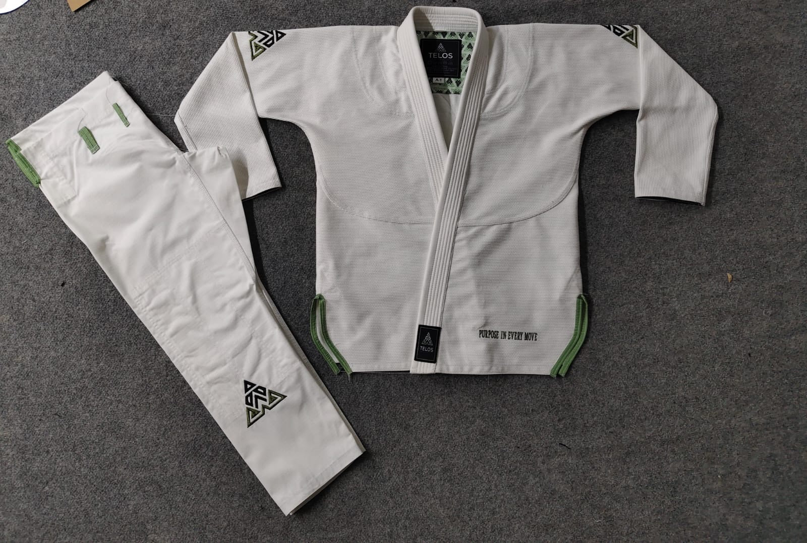 Completed white custom BJJ gi with academy branding and contrast details